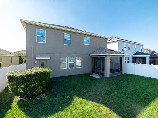 back of property featuring a sunroom, a fenced backyard, stucco siding, and a yard