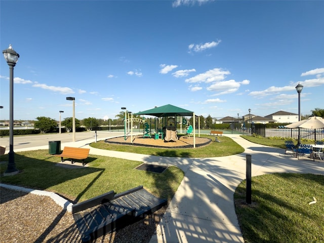 community jungle gym with a yard and fence