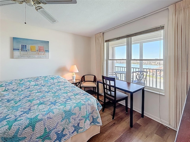 bedroom with a textured ceiling, wood finished floors, and a ceiling fan