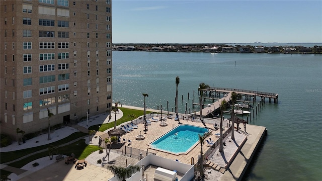 exterior space with a patio, a community pool, fence, and a water view