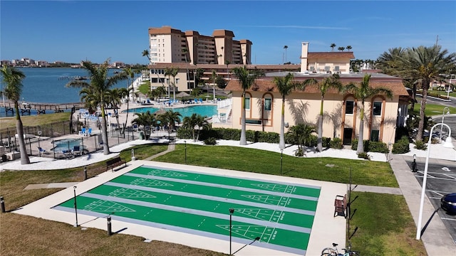 view of community featuring shuffleboard, a lawn, and fence