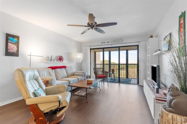 living room featuring ceiling fan, baseboards, and wood finished floors