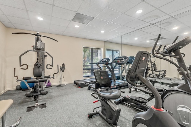 gym with a paneled ceiling, baseboards, and recessed lighting