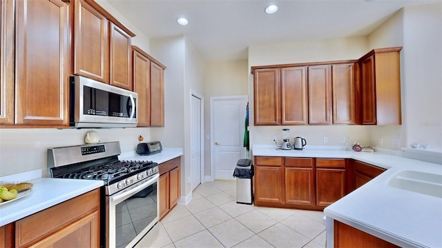 kitchen with light tile patterned floors, stainless steel appliances, recessed lighting, light countertops, and a sink