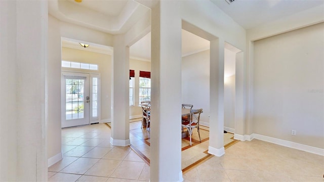 entrance foyer with light tile patterned floors, baseboards, and ornate columns