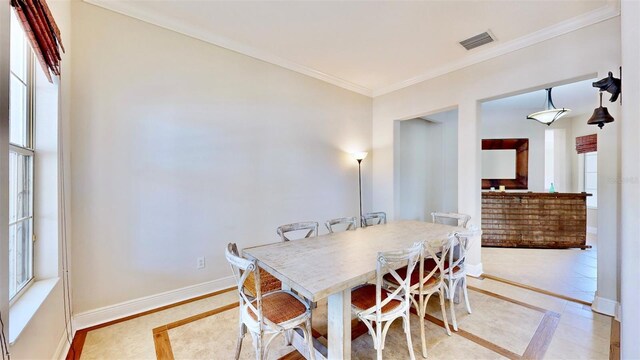 dining area featuring visible vents, crown molding, and baseboards