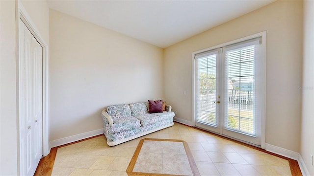 sitting room featuring french doors, baseboards, and tile patterned floors