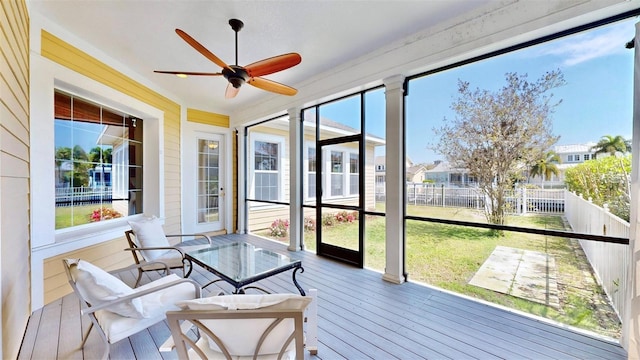 sunroom featuring a residential view and ceiling fan