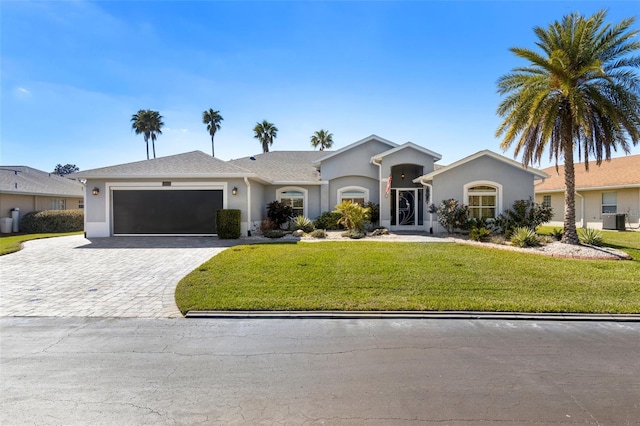 ranch-style home featuring a garage, decorative driveway, a front yard, and stucco siding