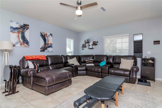 living room featuring light tile patterned floors, a ceiling fan, visible vents, and baseboards