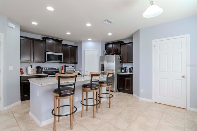 kitchen with appliances with stainless steel finishes, a breakfast bar area, visible vents, and recessed lighting