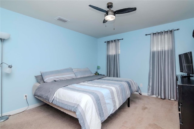 bedroom with light carpet, a ceiling fan, visible vents, and baseboards