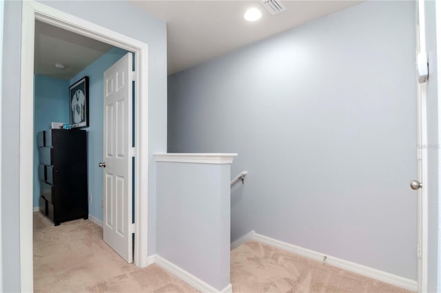 hall featuring visible vents, carpet, an upstairs landing, and baseboards