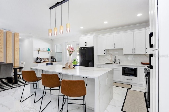 kitchen with tasteful backsplash, a kitchen island, marble finish floor, black appliances, and a sink