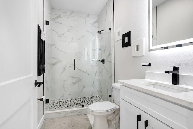 bathroom featuring marble finish floor, vanity, a marble finish shower, and toilet