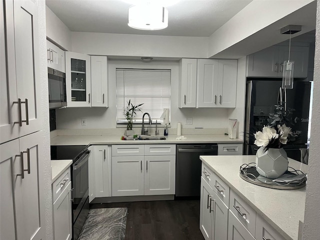 kitchen featuring dark wood-style floors, glass insert cabinets, white cabinets, a sink, and black appliances