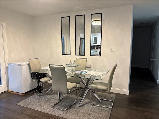 dining space featuring baseboards and wood finished floors