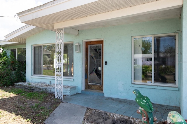 view of exterior entry with stucco siding