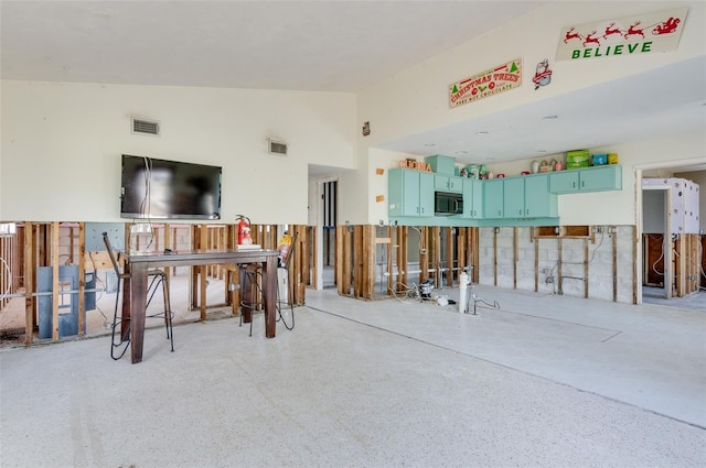 miscellaneous room with high vaulted ceiling, visible vents, and light speckled floor