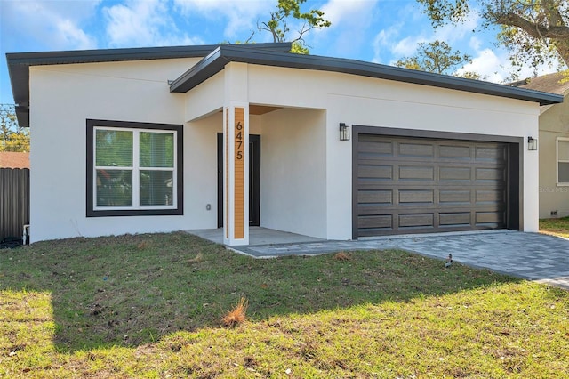 ranch-style home featuring an attached garage, a front lawn, decorative driveway, and stucco siding