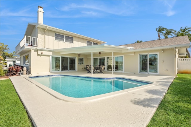 rear view of house with a patio, a balcony, ceiling fan, a chimney, and fence