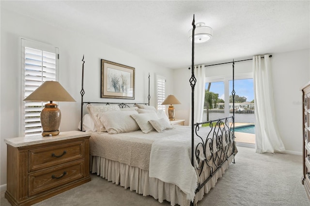 bedroom with light carpet, access to outside, and baseboards