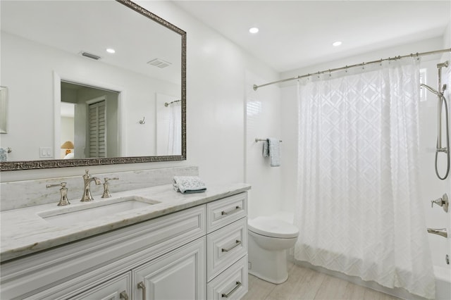 bathroom featuring shower / bath combination with curtain, recessed lighting, visible vents, toilet, and vanity