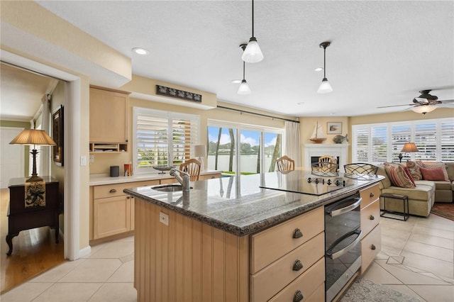 kitchen with a warming drawer, light tile patterned flooring, light brown cabinets, a sink, and black electric cooktop