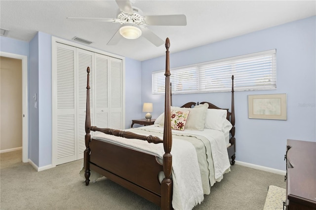 carpeted bedroom with a closet, visible vents, and baseboards