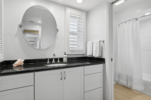 full bathroom with wood finished floors and vanity