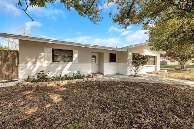 ranch-style house with brick siding and fence