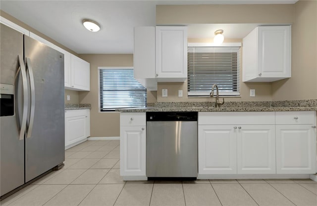 kitchen with light tile patterned floors, white cabinetry, and stainless steel appliances