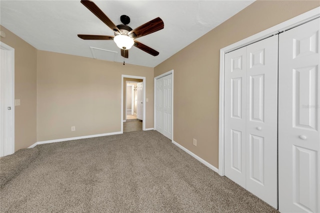 unfurnished bedroom with a ceiling fan, baseboards, multiple closets, and carpet floors