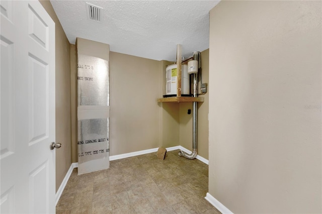 clothes washing area featuring visible vents, baseboards, and a textured ceiling