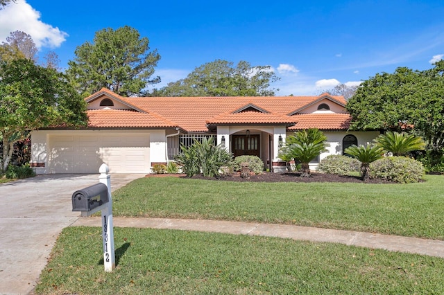 mediterranean / spanish-style house featuring a garage, concrete driveway, a tile roof, a front yard, and stucco siding