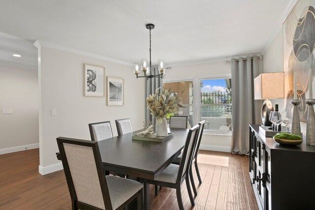 dining space featuring baseboards, ornamental molding, dark wood finished floors, and a notable chandelier