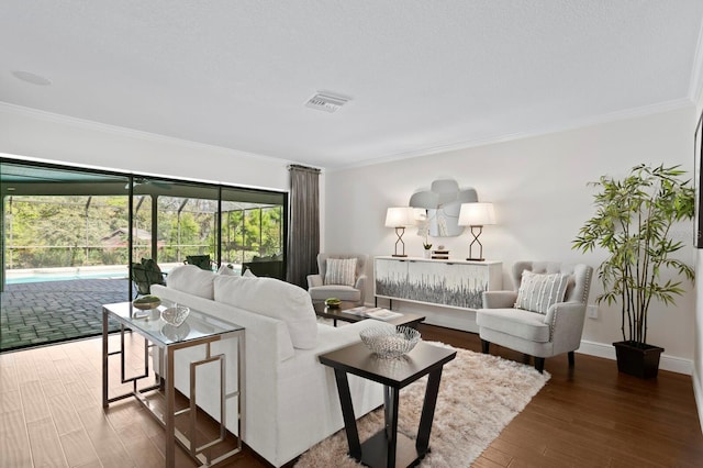 living area featuring baseboards, wood finished floors, visible vents, and crown molding