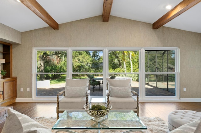 living room with lofted ceiling with beams, baseboards, and hardwood / wood-style flooring