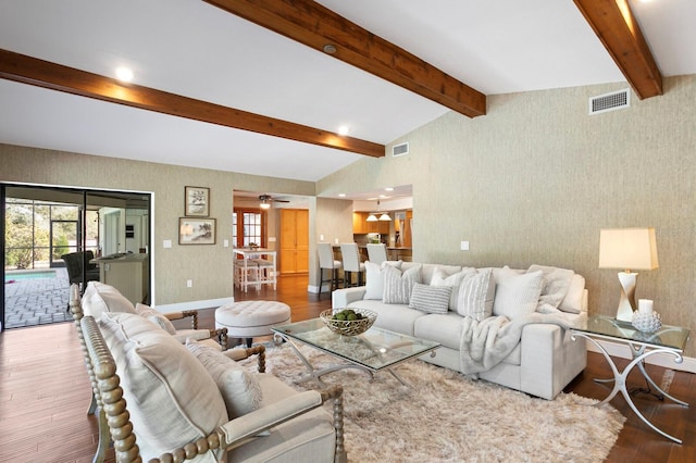 living room with wood finished floors, visible vents, vaulted ceiling with beams, and wallpapered walls