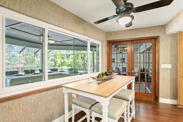 dining space with wallpapered walls, baseboards, a sunroom, dark wood-style floors, and french doors