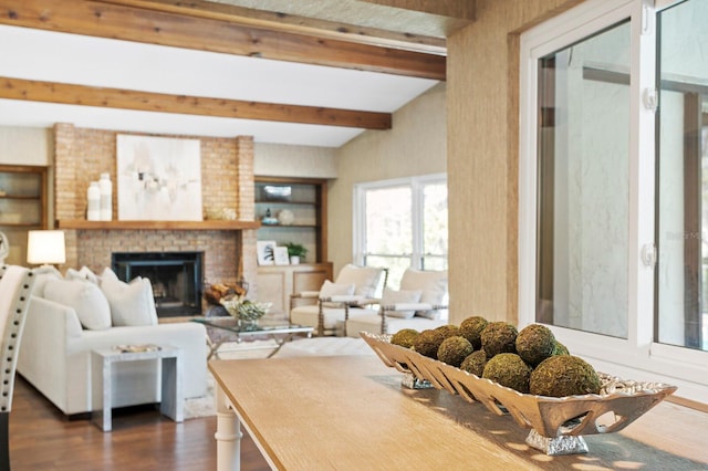 living area with dark wood-style floors, a fireplace, and beamed ceiling