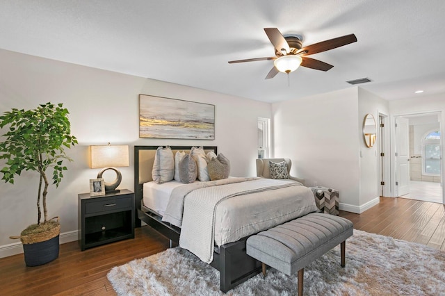 bedroom with baseboards, visible vents, dark wood finished floors, connected bathroom, and ceiling fan