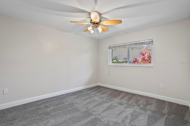 carpeted empty room featuring ceiling fan and baseboards