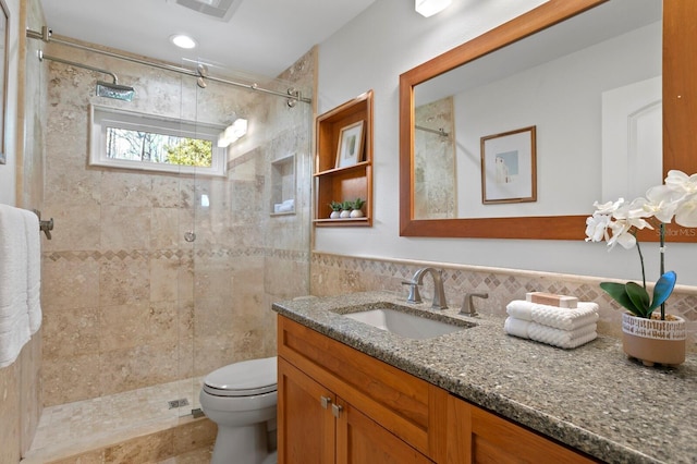 full bath featuring visible vents, vanity, a tile shower, and toilet