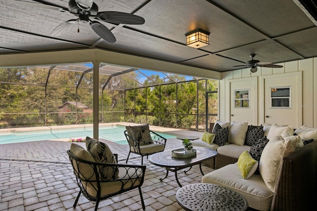 view of patio / terrace with an outdoor pool, glass enclosure, an outdoor hangout area, and a ceiling fan