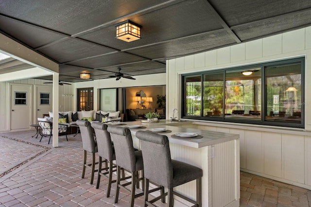 view of patio featuring ceiling fan, outdoor dry bar, outdoor lounge area, and a sink