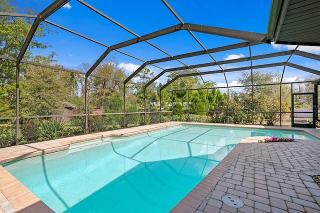 pool featuring glass enclosure and a patio