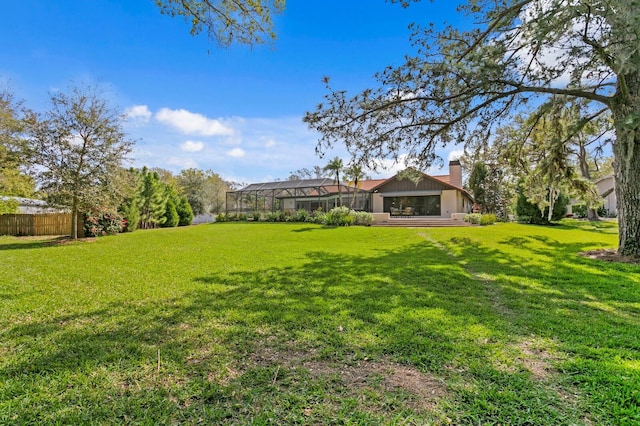 view of yard featuring glass enclosure and fence