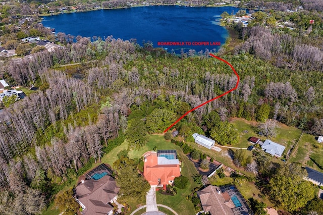 birds eye view of property featuring a water view and a view of trees