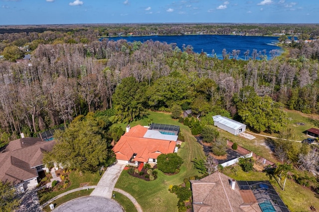 drone / aerial view with a water view and a forest view